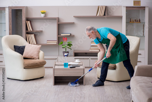 Old male contractor cleaning the house