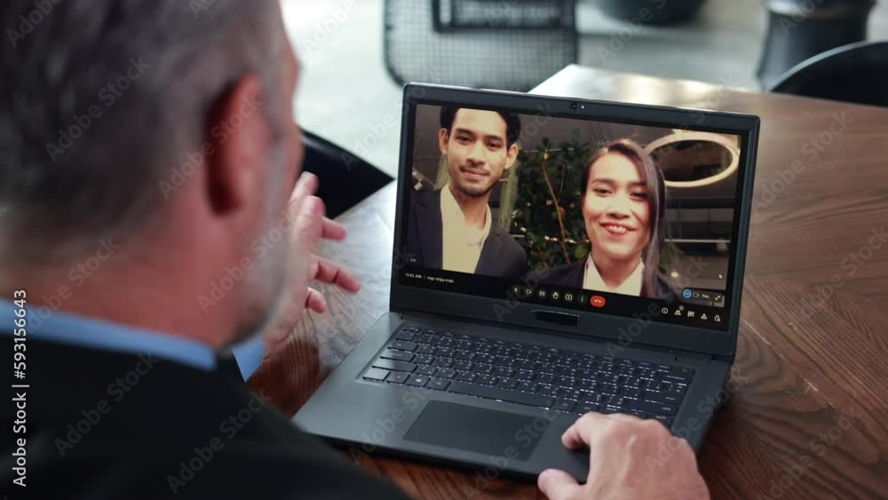 Back view of senior business man talking with business partners Asian male and female on Zoom video call programs at home office Back view of senior business man talking with business partners Asian male and female on Zoom video call programs at home office