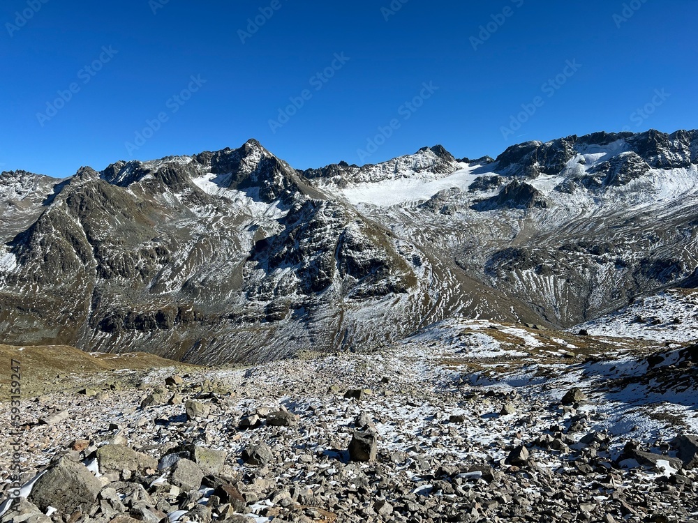 Fototapeta premium Rocky mountain peaks Piz Sarsura Pitschen (3132 m), Piz Sarsura (3176 m) and Grippa Naira (3130 m) in Albula Alps and above the alpine valley Val Grialetsch, Zernez - Canton of Grisons, Switzerland