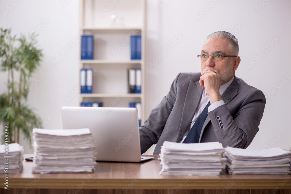 Old male employee and too much work at workplace Old male employee and too much work at workplace