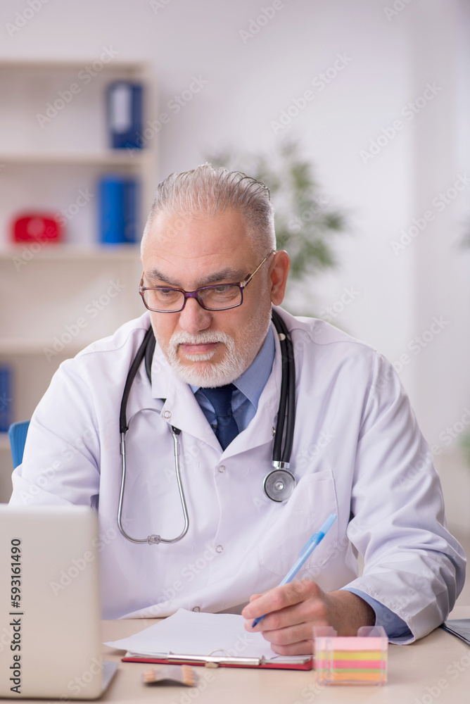 Old male doctor working in the clinic Old male doctor working in the clinic