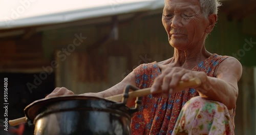 Wallpaper Mural Slow motion Asian rural life in the evening sunset time which is a poor elderly woman, farmer and employee in the farm, cooking rice using a stove with firewood in front of her old house. Torontodigital.ca