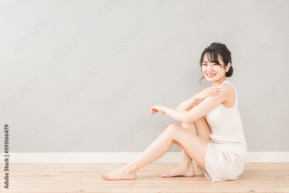 Fototapeta premium ボディケア・脱毛・保湿・日焼け止めを塗る笑顔のアジア人女性