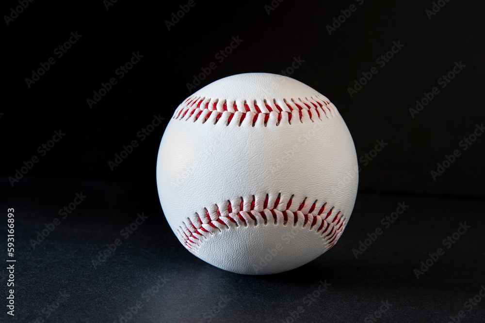 Close-up of a white baseball with red stitching on a black background Close-up of a white baseball with red stitching on a black background