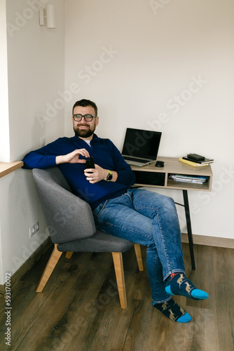 man sits at a desk with a laptop and books and thinks about business photo