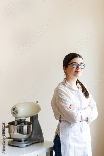 girl confectioner entrepreneur in her kitchen while cooking photo