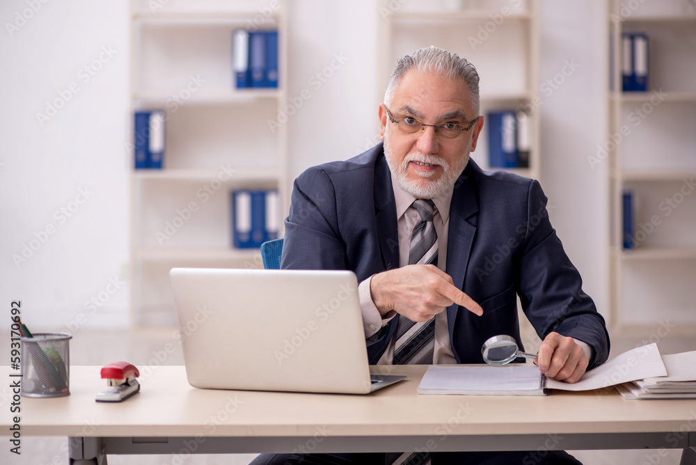 Old male employee working in the office Old male employee working in the office