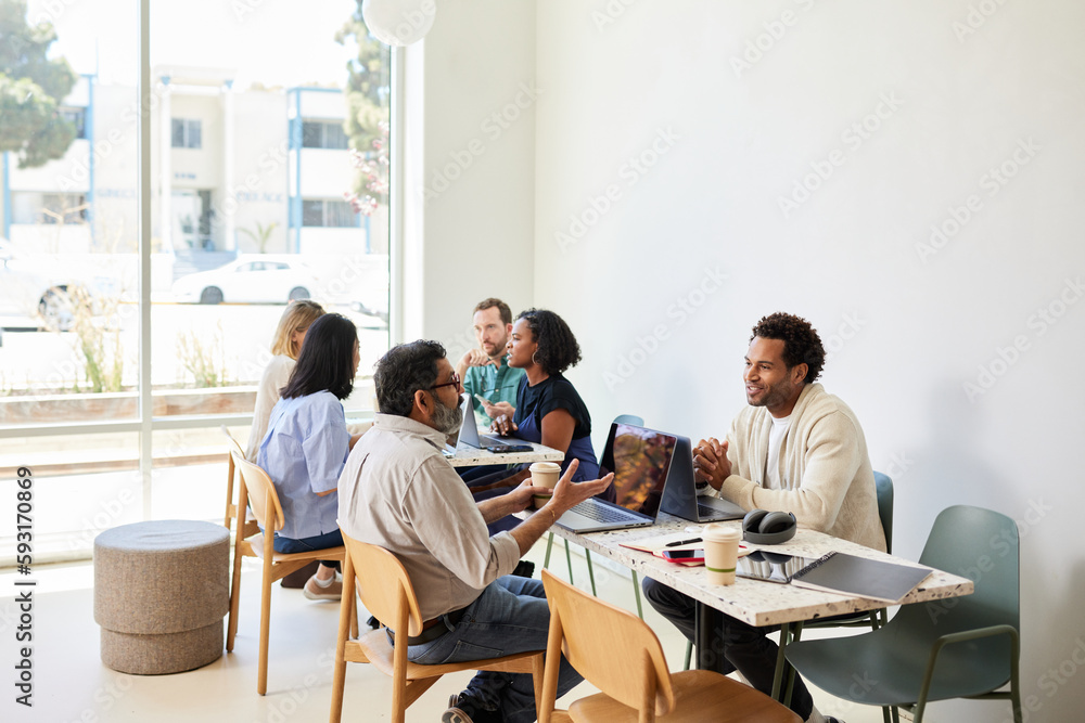 Multiracial colleagues discussing while sitting in coffee shop Multiracial colleagues discussing while sitting in coffee shop