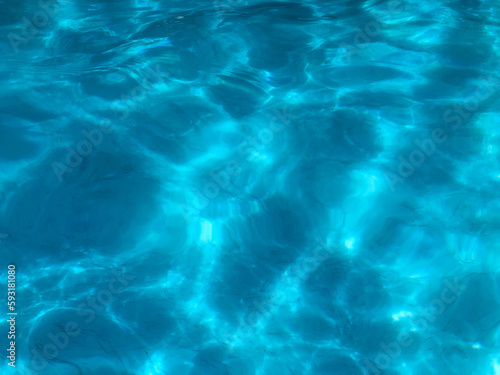 Dramatic blue swimming pool water surface dazzling reflection