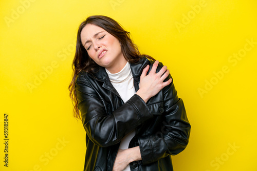Young caucasian woman isolated on yellow background suffering from pain in shoulder for having made an effort