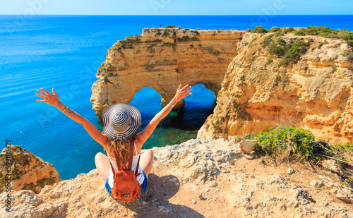 Woman tourist enjoying panoramic view of beautiful algarve heart shaped cliff on atlantic ocean- travel destination, summer vacation travel concept- Portugal ( praia da Marinha, carvoeiro, benagil)