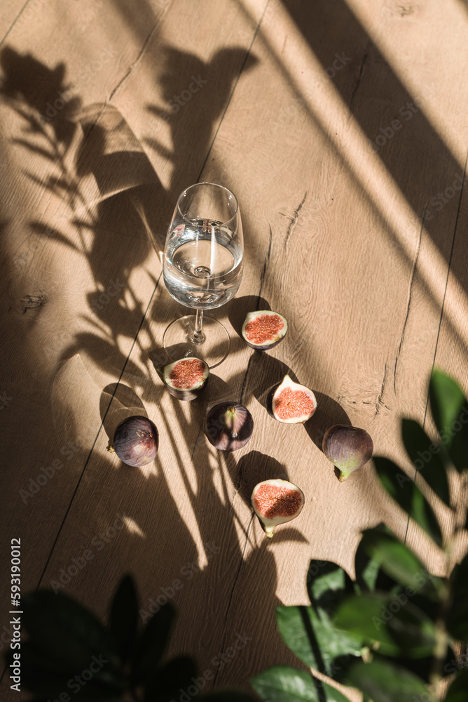 glass of water with figs on the wood table