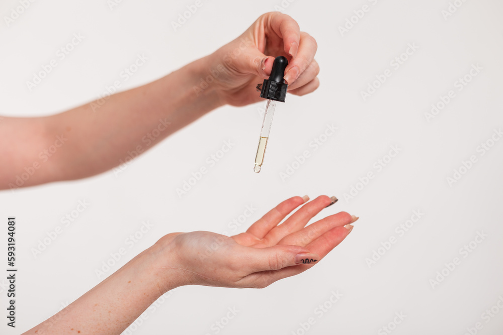 Beautiful woman's hands holding a dropper of oil and skin care. Beauty and Health. Cosmetics Beautiful woman's hands holding a dropper of oil and skin care. Beauty and Health. Cosmetics