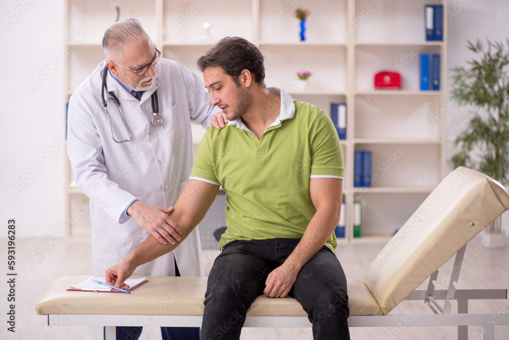 Fototapeta premium Young male patient visiting old male doctor