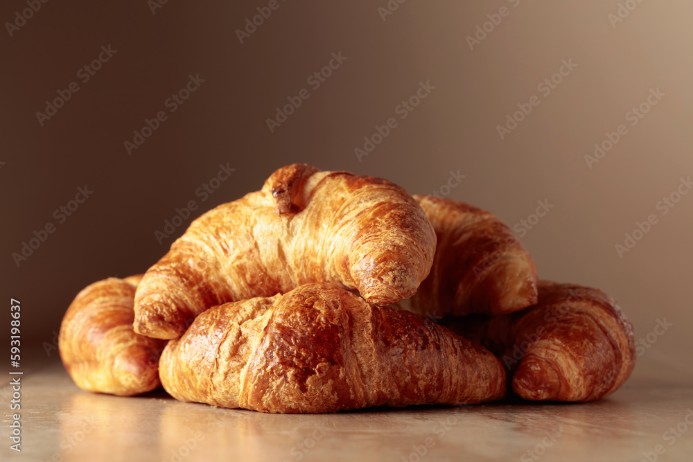 Freshly baked croissants on a beige ceramic table.
