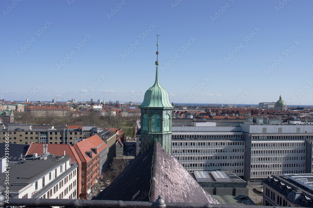Aerial cityscape of the center of Copenhagen with in the foreground the tower of the Trinitatis church in Denmark with a clear blue sky