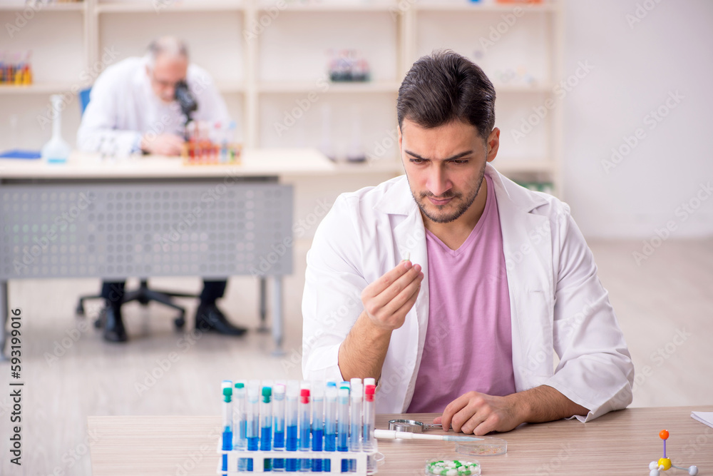 Two male chemists working at the lab Two male chemists working at the lab