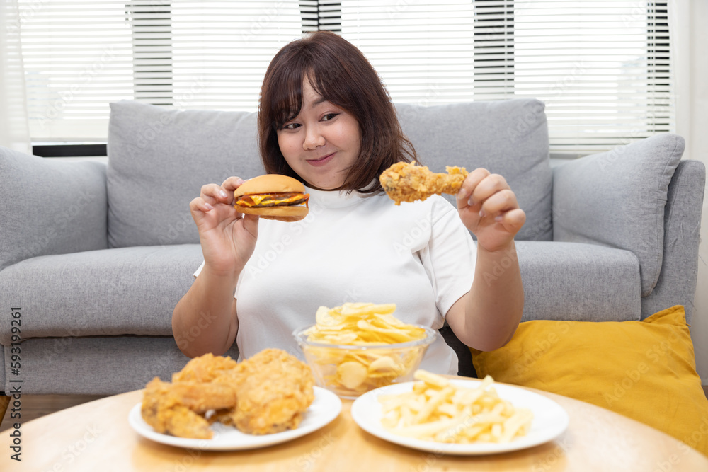 Chubby Asian Woman Enjoy Eatting Beef Cheese Burger and Fried Drumstick Chicken Chubby Asian Woman Enjoy Eatting Beef Cheese Burger and Fried Drumstick Chicken