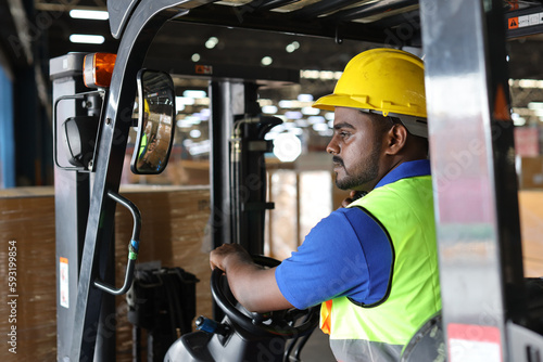 Warehouse workers or forklift driver man with hardhats and reflective jackets in vehicle using walkie talkie radio controlling stock and inventory in retail warehouse logistics, distribution center