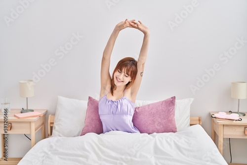 Wallpaper Mural Young woman wearing nightgown stretching arms at bedroom Torontodigital.ca