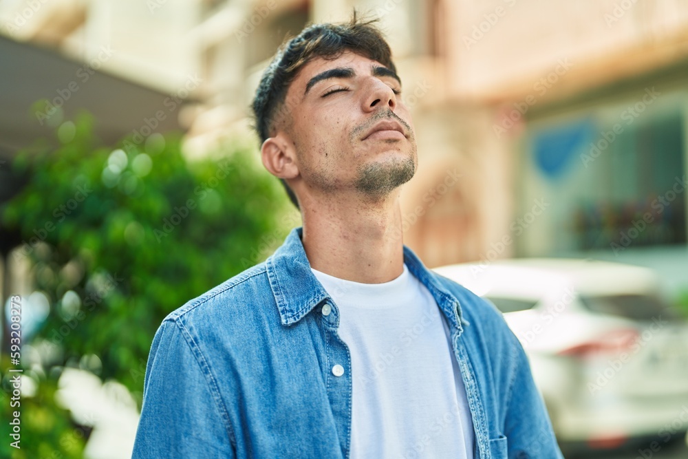 Young hispanic man breathing with closed eyes at street Young hispanic man breathing with closed eyes at street