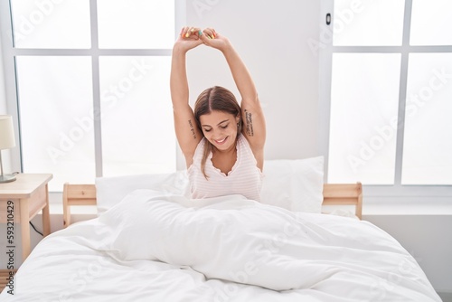 Wallpaper Mural Young beautiful hispanic woman waking up stretching arms at bedroom Torontodigital.ca
