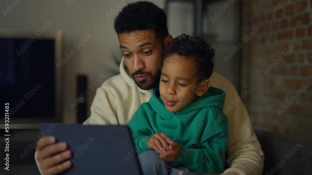 Father with his son having a call on digital tablet, enjoying time together. Father with his son having a call on digital tablet, enjoying time together.