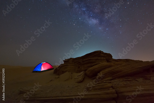 Fossil Rock dune in the desert of empty quarter at night milky way while camping