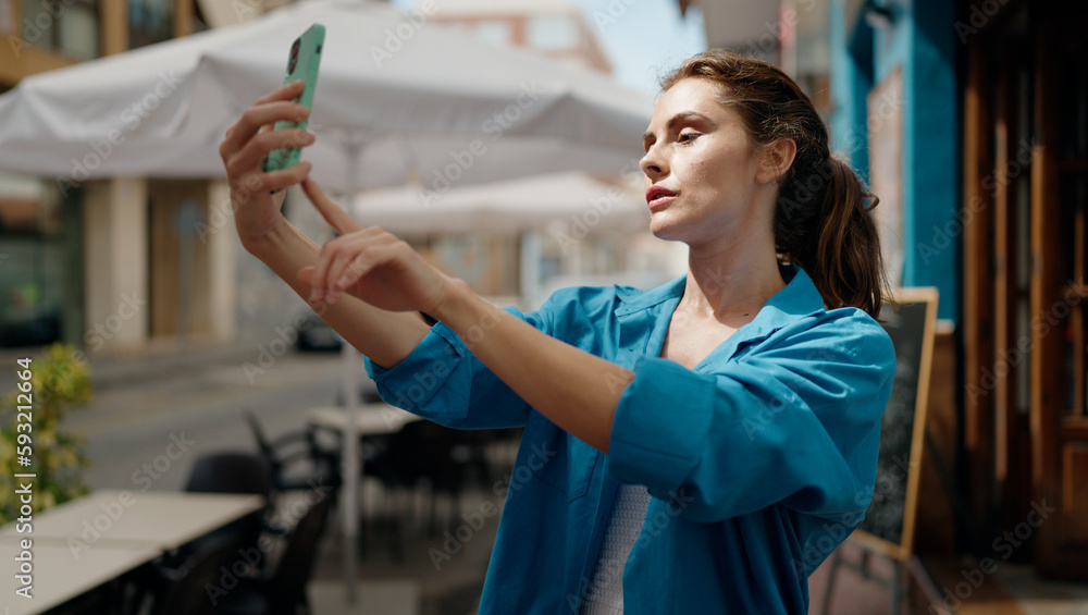 Young woman making selfie by the smartphone at street