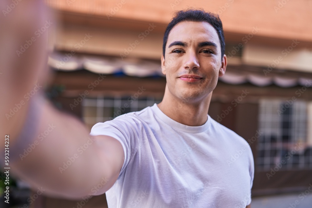 Young hispanic man smiling confident making selfie by camera at coffee shop terrace Young hispanic man smiling confident making selfie by camera at coffee shop terrace