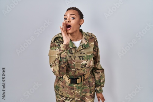 Beautiful african american woman wearing camouflage army uniform hand on mouth telling secret rumor  whispering malicious talk conversation