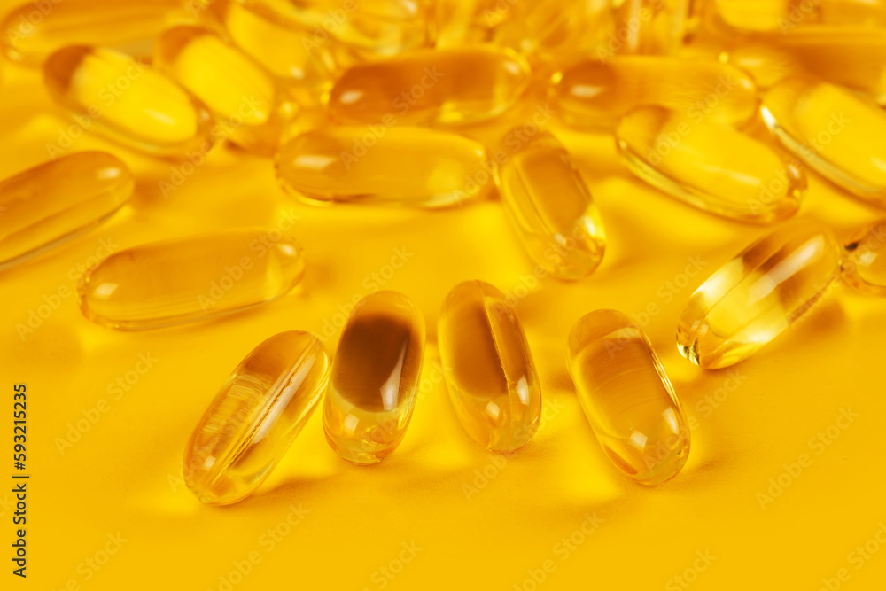 Vitamin e omega 3 fish oil yellow pills vitamins sport nutrition healthy on the yellow background isolated close up Vitamin e omega 3 fish oil yellow pills vitamins sport nutrition healthy on the yellow background isolated close up