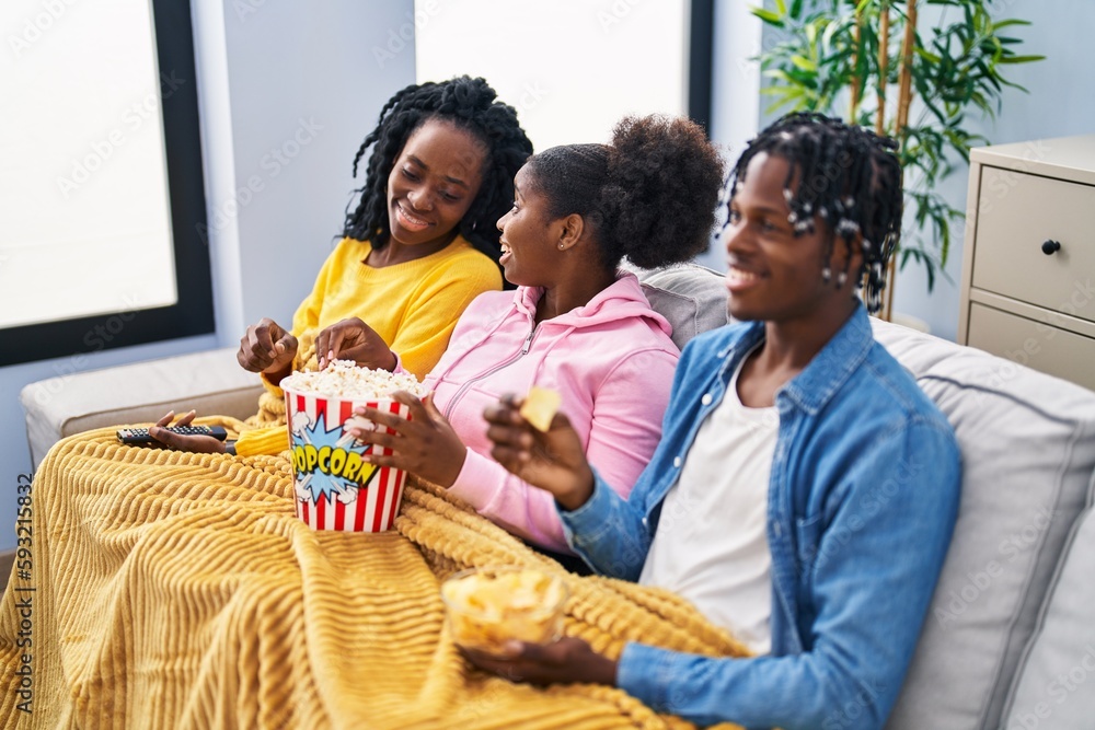 African american friends watching movie sitting on sofa at home African american friends watching movie sitting on sofa at home