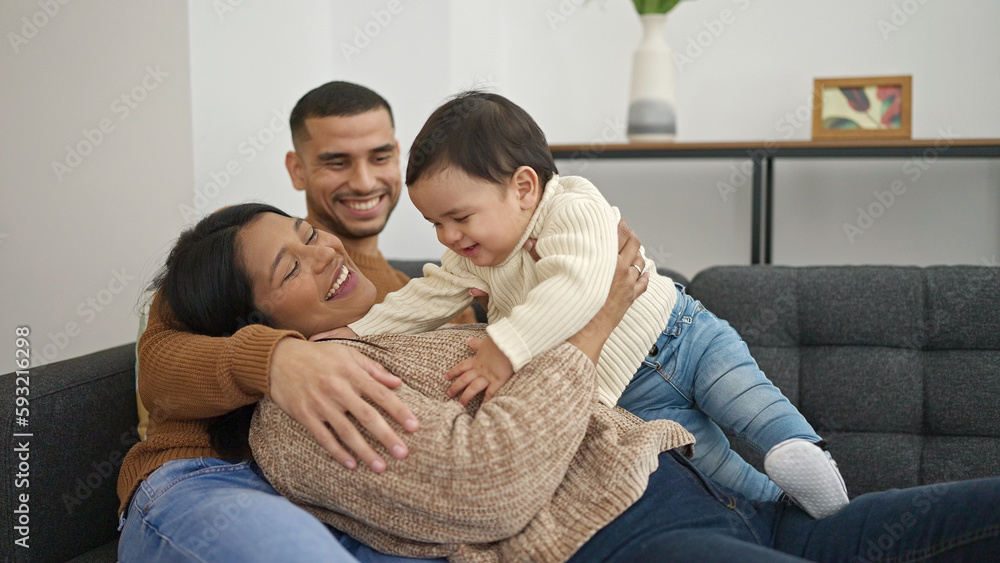 Couple and son hugging each other sitting on sofa at home Couple and son hugging each other sitting on sofa at home