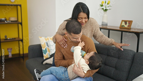 Couple and son drinking milk by feeding bottle at home