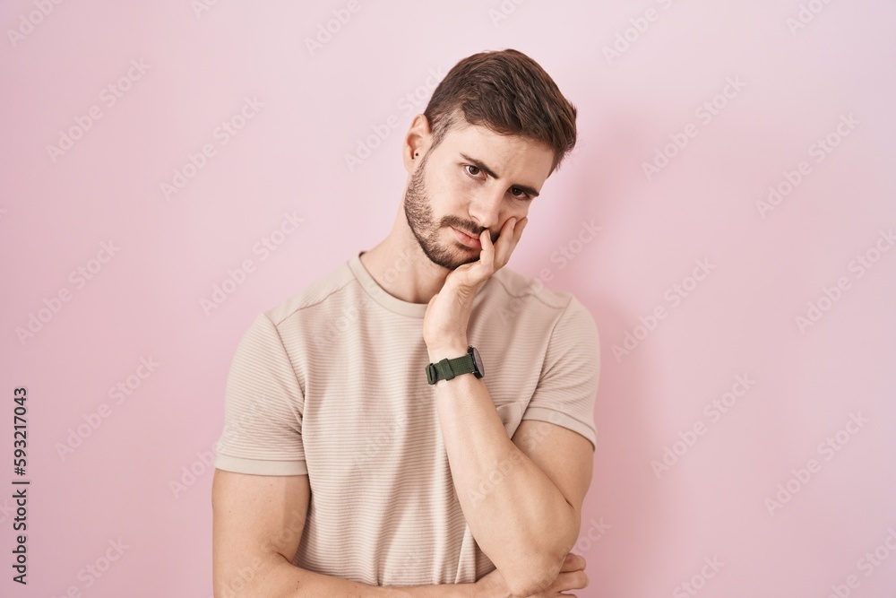 Hispanic man with beard standing over pink background thinking looking tired and bored with depression problems with crossed arms. Hispanic man with beard standing over pink background thinking looking tired and bored with depression problems with crossed arms.