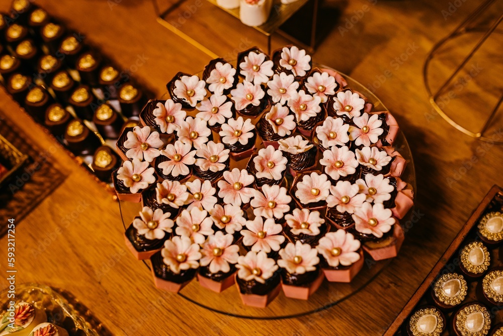 Top view of chocolate pieces with Cherry blossom flowers on a table on wooden table Top view of chocolate pieces with Cherry blossom flowers on a table on wooden table
