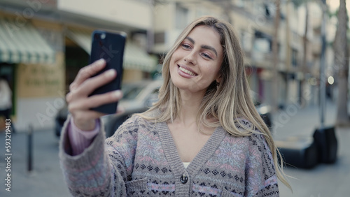 Wallpaper Mural Young blonde woman smiling confident making selfie by the smartphone at street Torontodigital.ca
