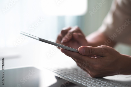 Close up of student hands using tablet for electronic learning. E-learning technology concept
