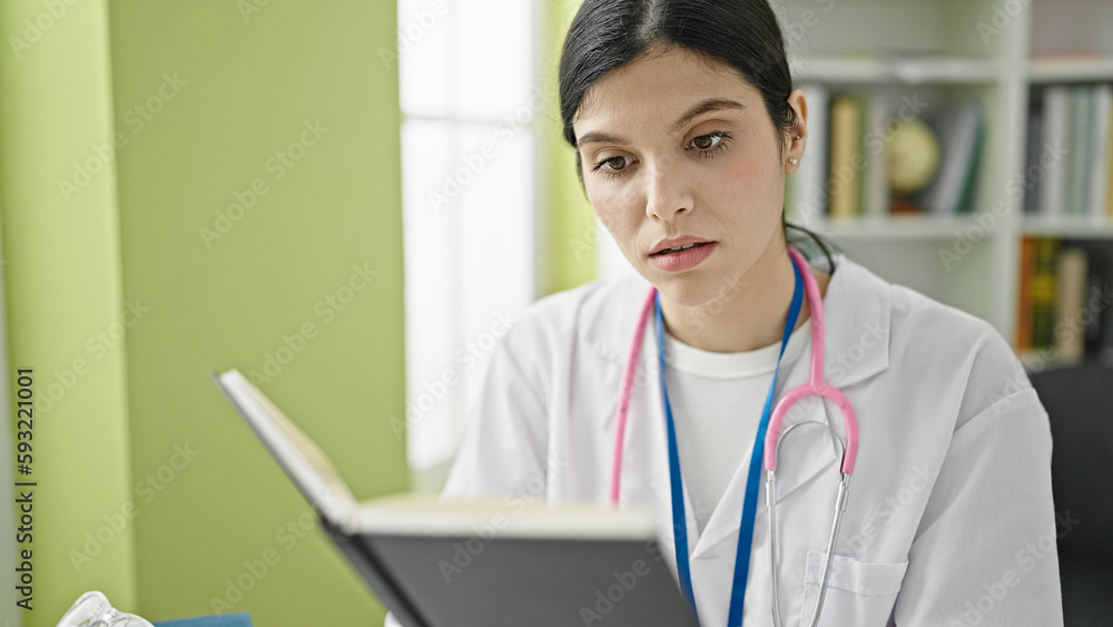 Young beautiful hispanic woman doctor reading book at library university Young beautiful hispanic woman doctor reading book at library university