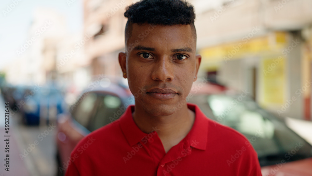 Fototapeta premium Young latin man with relaxed expression standing at street