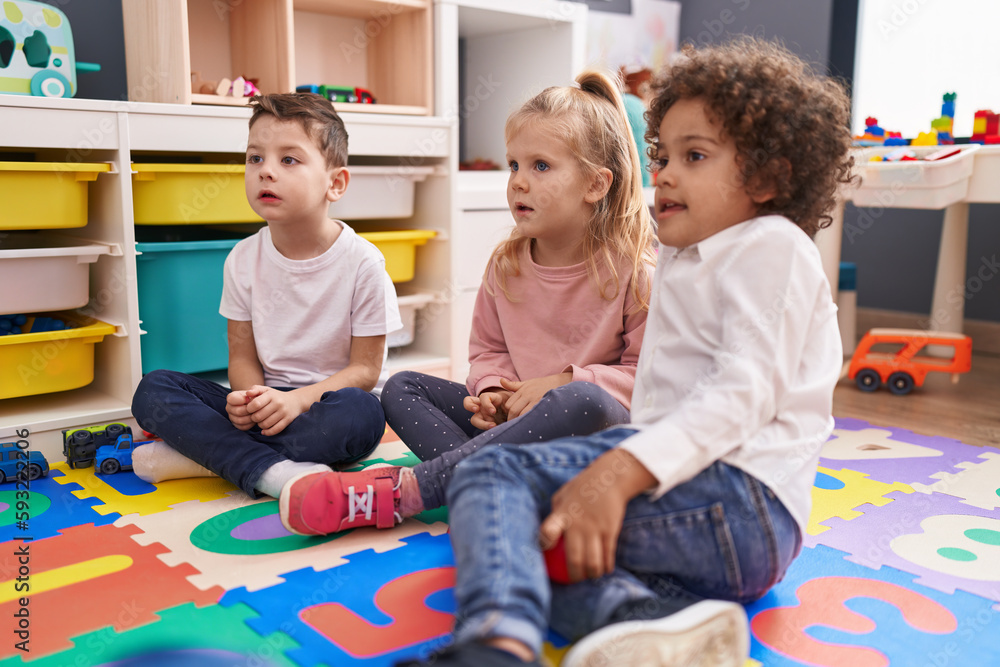 Group of kids sitting on floor with relaxed expression at kindergarten Group of kids sitting on floor with relaxed expression at kindergarten