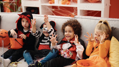 Group of kids wearing halloween costume doing scare gesture at home