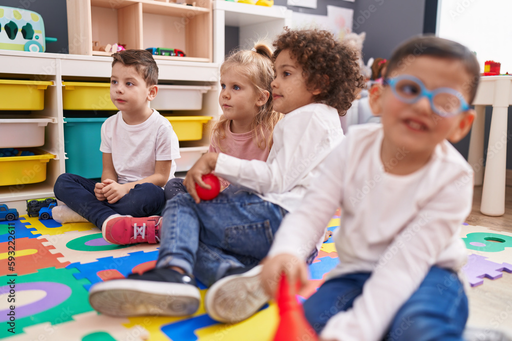Obraz premium Group of kids sitting on floor smiling confident at kindergarten