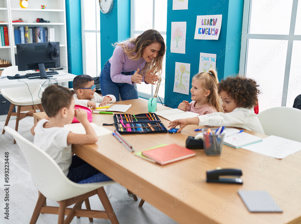 Woman and group of kids having lesson clapping hands at classroom Woman and group of kids having lesson clapping hands at classroom
