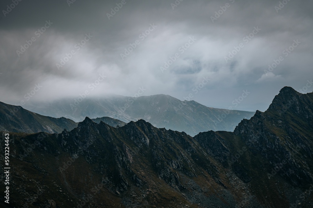 Scenic view of a mountain range covered with clouds on a foggy day