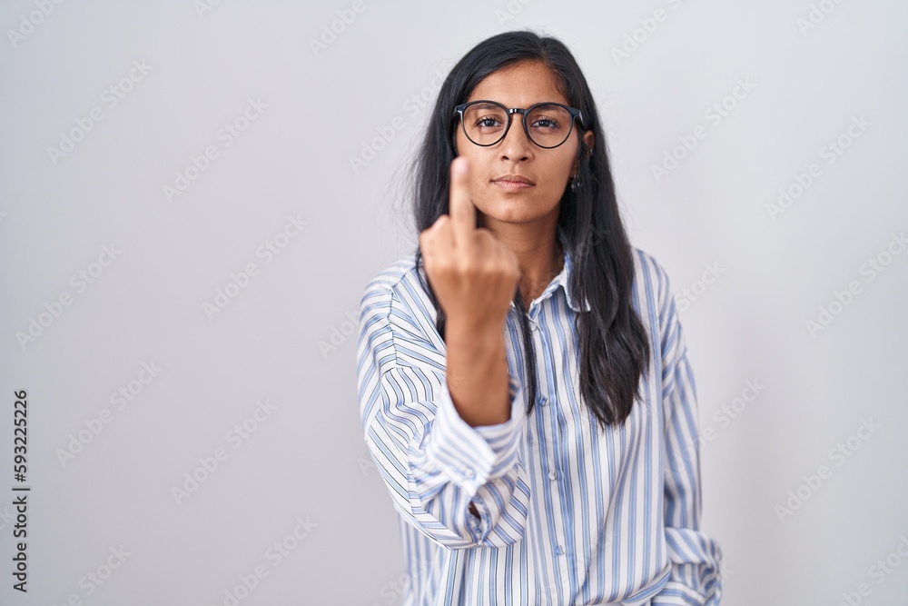 Young hispanic woman wearing glasses showing middle finger, impolite and rude fuck off expression Young hispanic woman wearing glasses showing middle finger, impolite and rude fuck off expression