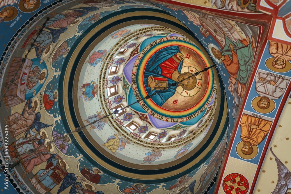 Low-angle shot of the murals and paintings on the walls and the dome of a Christian church