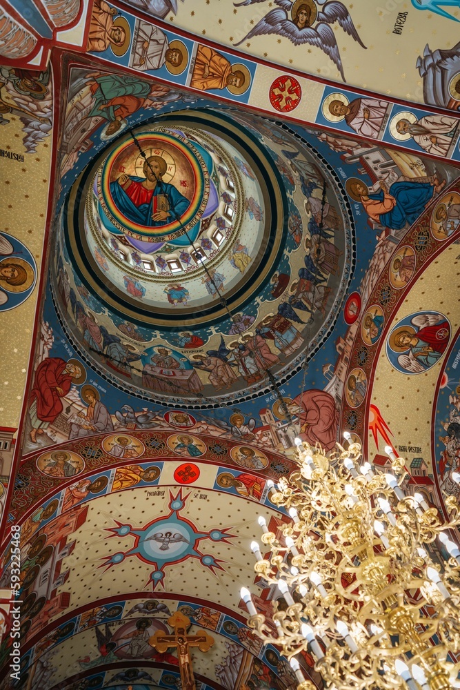 Low-angle shot of the murals and paintings on the walls and the dome of a Christian church