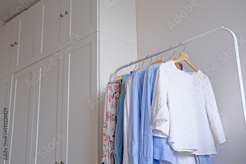 Rack with hanging clothes in the interior of the dressing room.